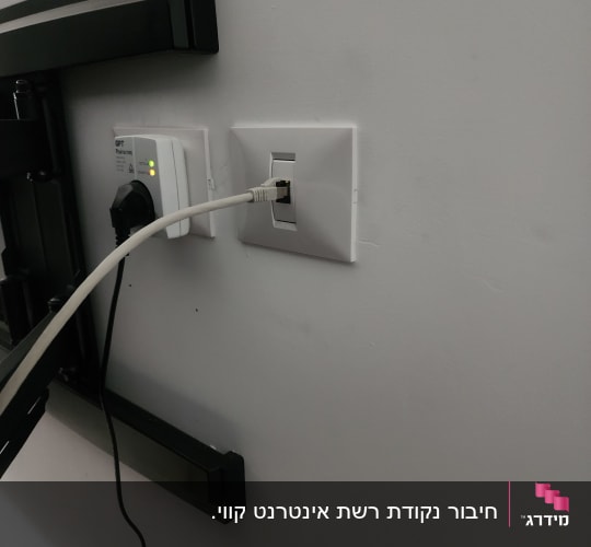 שקע רשת בודד מותקן בקיר ומחובר לכבל תקשורת לצד מתקן טלוויזיה
